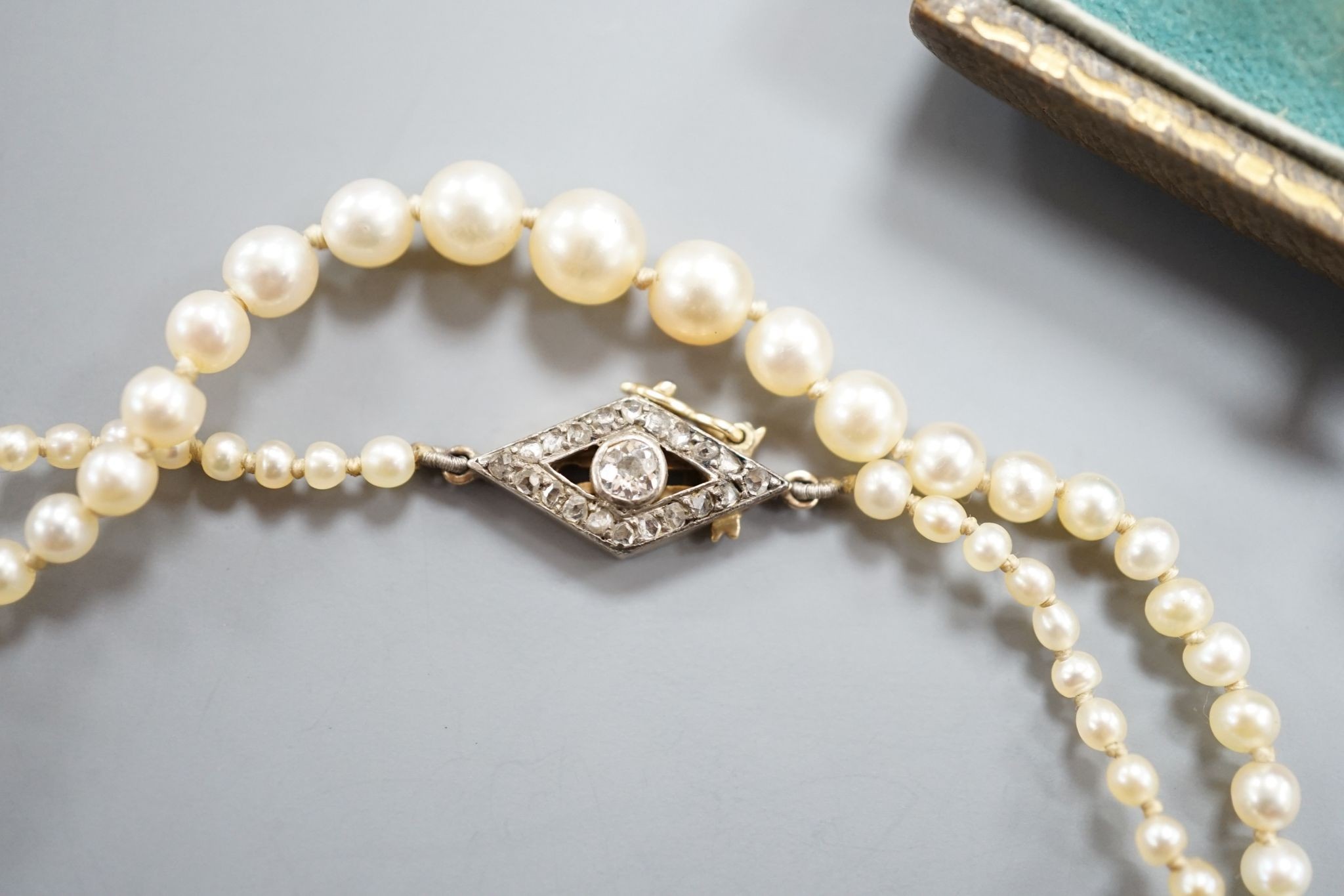 A single strand graduated seed pearl necklace, with yellow metal and diamond set clasp 42cm and a cased pair of similar Austro Hungarian ear clips.